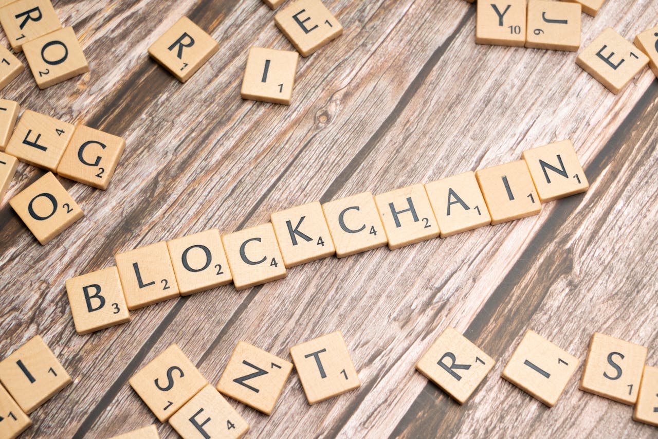 Wooden letter tiles form the word 'blockchain' arranged on a rustic wood background.
